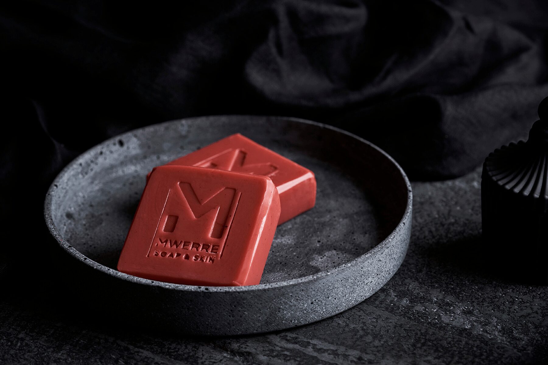 Indigenous Red clay square shaped soaps on a round gray plate